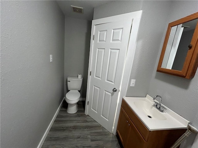 bathroom featuring wood-type flooring, vanity, and toilet