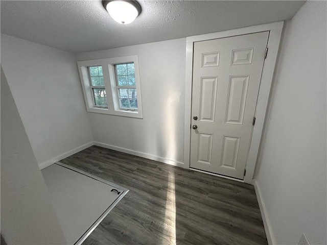 empty room with a textured ceiling and dark hardwood / wood-style floors