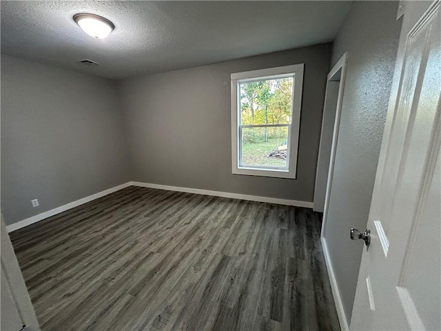 unfurnished room featuring a textured ceiling and dark wood-type flooring