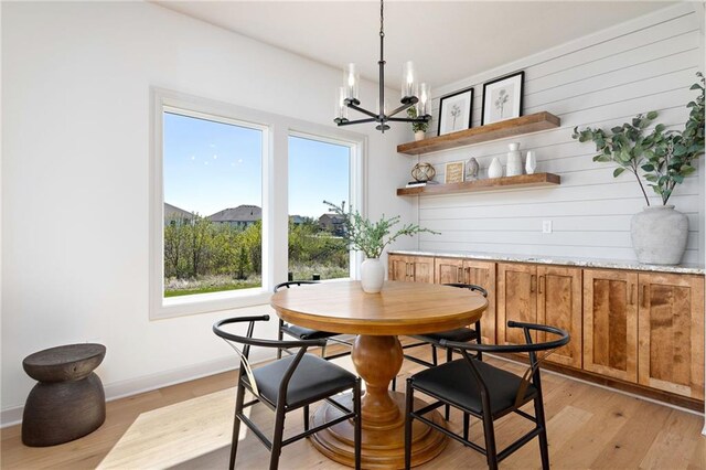 dining area featuring a chandelier, light wood-type flooring, and baseboards