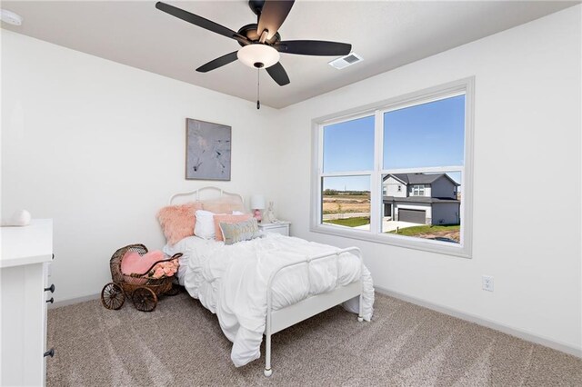 carpeted bedroom featuring baseboards, visible vents, and a ceiling fan