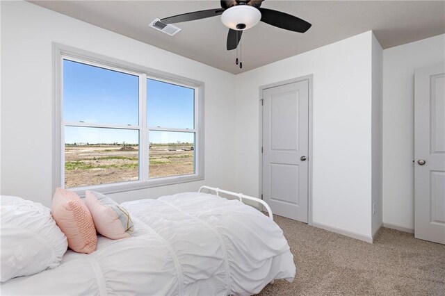 bedroom with light colored carpet, visible vents, ceiling fan, and baseboards