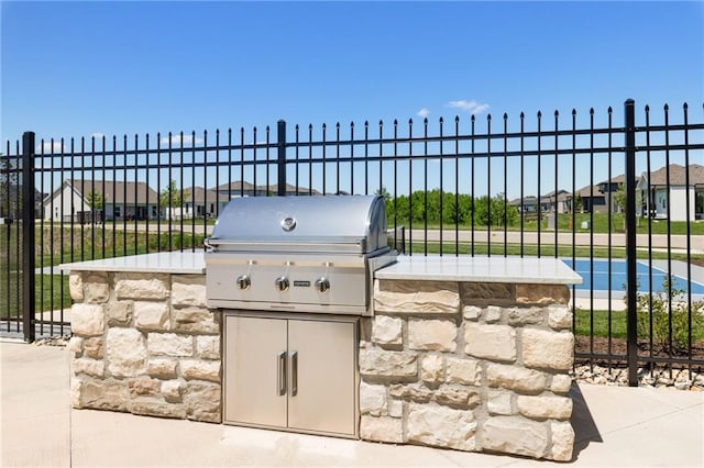 view of patio / terrace with an outdoor kitchen, fence, and grilling area