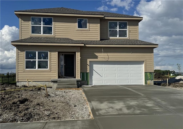 view of front of home featuring roof with shingles, an attached garage, and concrete driveway