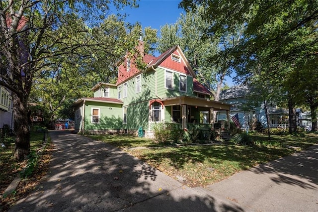 victorian house featuring a front yard and a porch