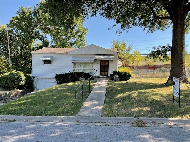 view of front of property with a front yard and a garage