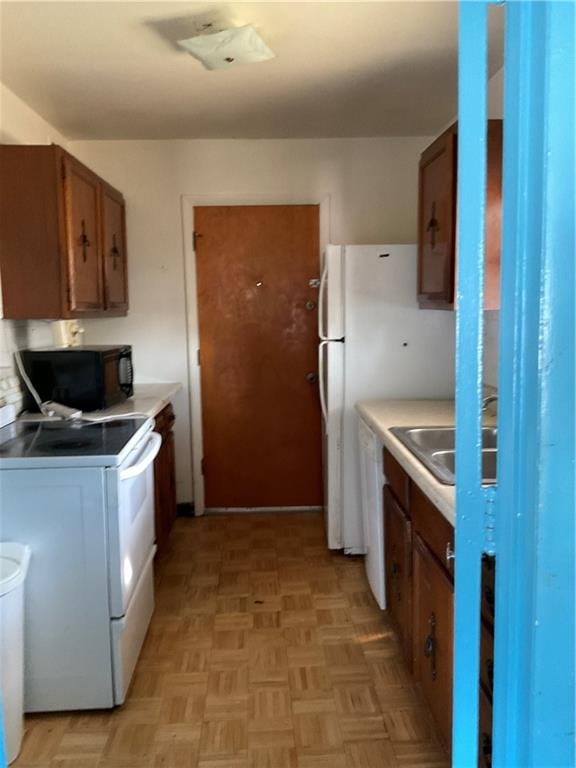 kitchen with white appliances and light parquet floors