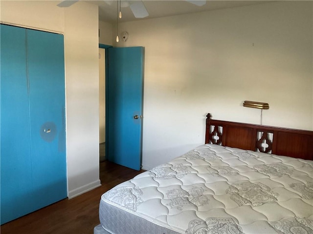 bedroom featuring dark wood-type flooring, ceiling fan, and a closet