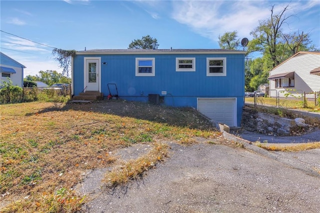 view of front of house with a garage and central AC