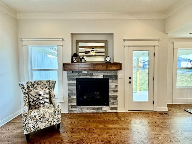 sitting room with ornamental molding, ceiling fan, a fireplace, and dark hardwood / wood-style flooring