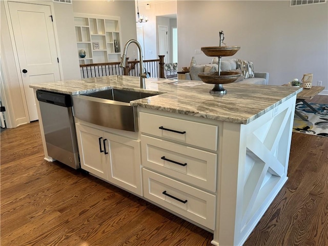 kitchen featuring sink, light stone counters, hanging light fixtures, a center island with sink, and dishwasher