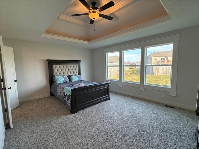 bedroom with ceiling fan, ornamental molding, a tray ceiling, and carpet