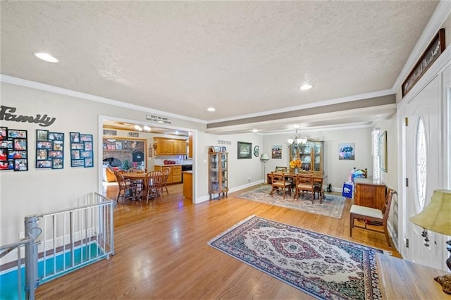 interior space featuring a textured ceiling, a chandelier, ornamental molding, and wood finished floors