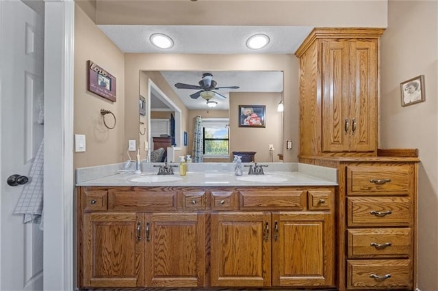 ensuite bathroom with double vanity, a sink, ceiling fan, and ensuite bathroom