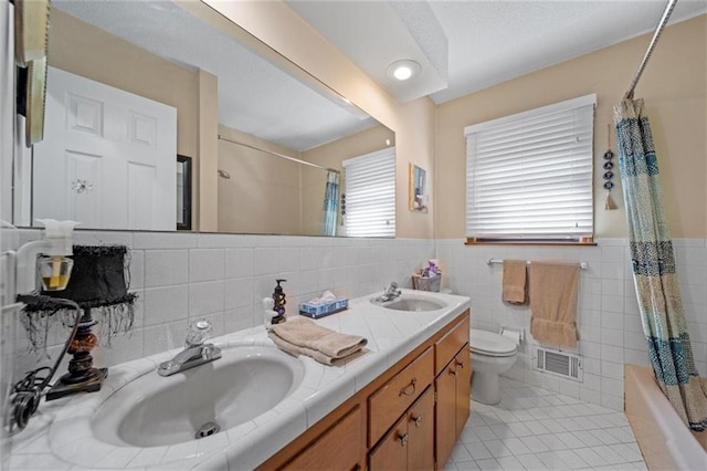 full bath featuring visible vents, tile walls, a sink, tile patterned floors, and toilet