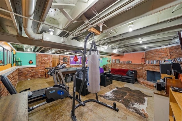 workout room featuring brick wall