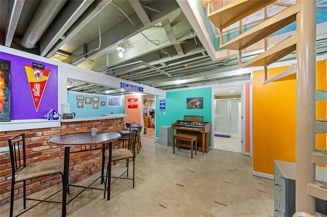 game room with indoor bar and concrete floors