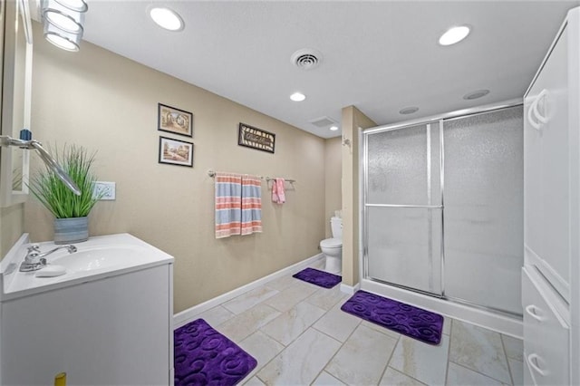 bathroom with vanity, toilet, recessed lighting, baseboards, and a stall shower