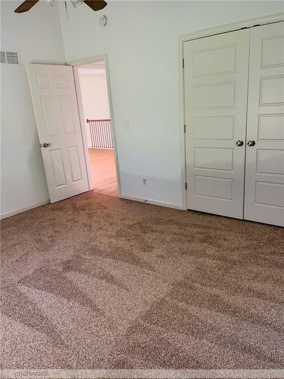 unfurnished bedroom with ceiling fan, a closet, and carpet flooring