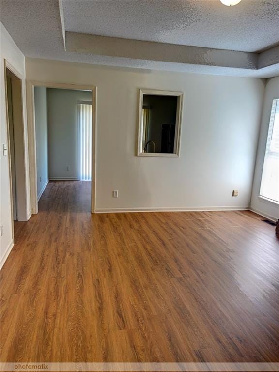 unfurnished room featuring a textured ceiling and hardwood / wood-style floors