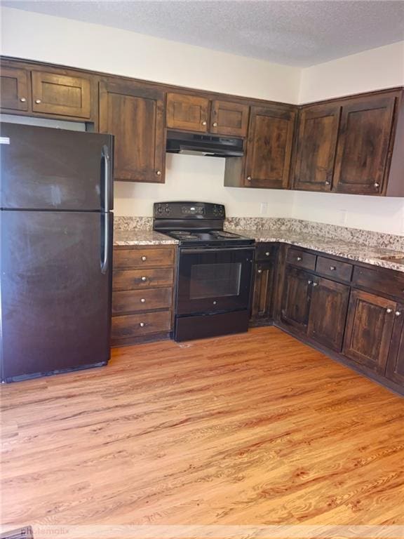 kitchen featuring light wood-type flooring, light stone counters, a textured ceiling, black appliances, and dark brown cabinetry