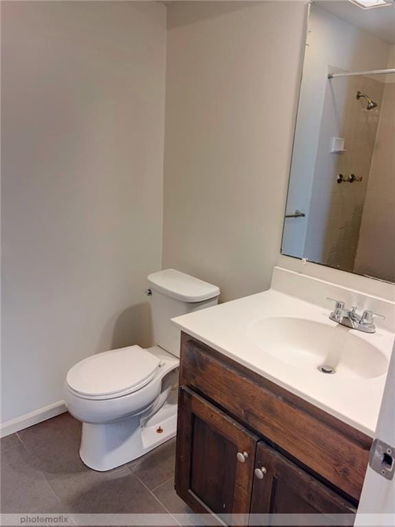 bathroom featuring tiled shower, tile patterned flooring, vanity, and toilet