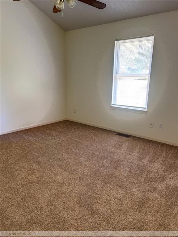 carpeted spare room featuring ceiling fan