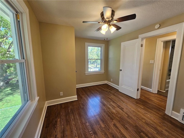 unfurnished bedroom with a textured ceiling, ceiling fan, and dark hardwood / wood-style flooring