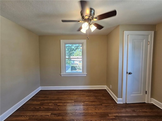 empty room with ceiling fan, a textured ceiling, and dark wood-type flooring