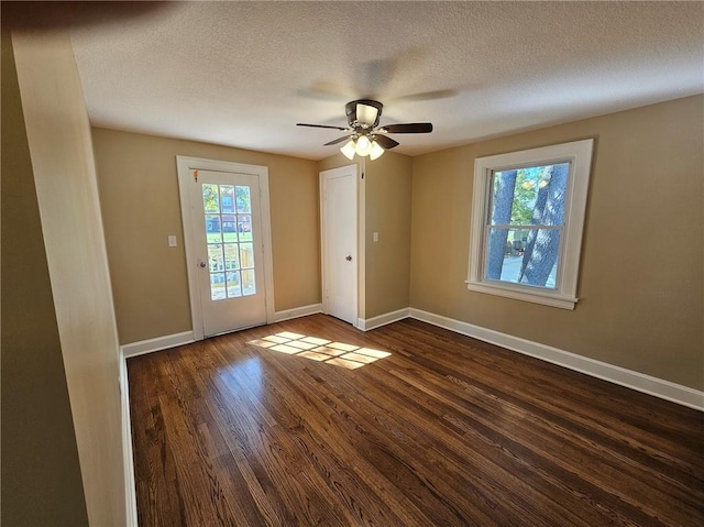 spare room with a textured ceiling, dark hardwood / wood-style flooring, and ceiling fan