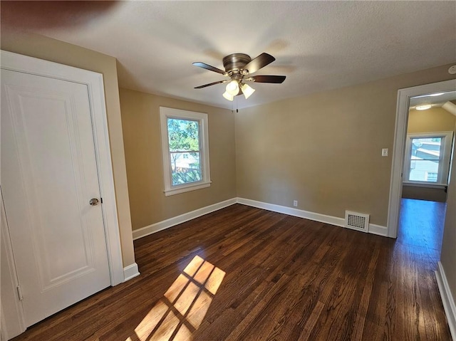 empty room featuring ceiling fan and dark wood-type flooring