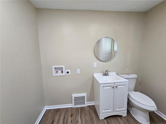 bathroom featuring vanity, hardwood / wood-style floors, and toilet