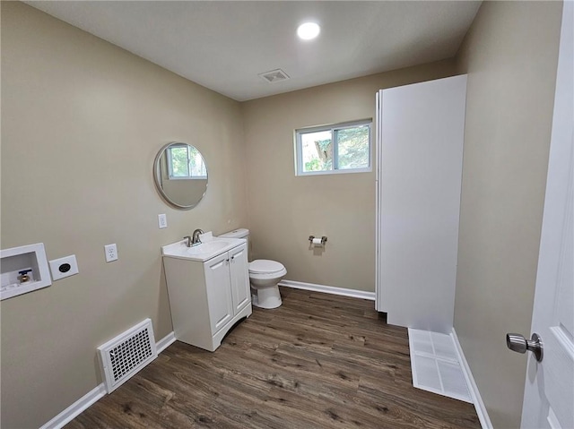 bathroom featuring wood-type flooring, vanity, and toilet