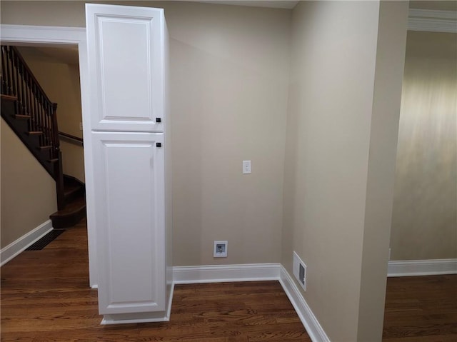 clothes washing area with cabinets, washer hookup, and dark hardwood / wood-style flooring