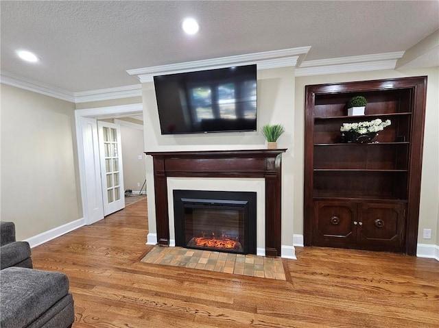 living room with light wood-type flooring, a textured ceiling, and crown molding