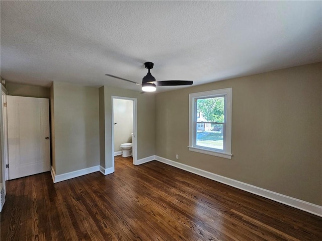 unfurnished bedroom with a textured ceiling, ceiling fan, ensuite bathroom, and dark hardwood / wood-style flooring