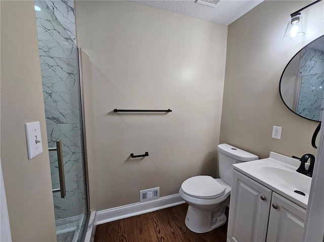 bathroom featuring vanity, walk in shower, a textured ceiling, hardwood / wood-style floors, and toilet