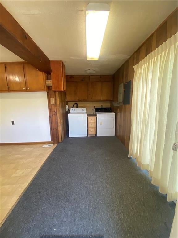 kitchen featuring wood walls and washing machine and dryer