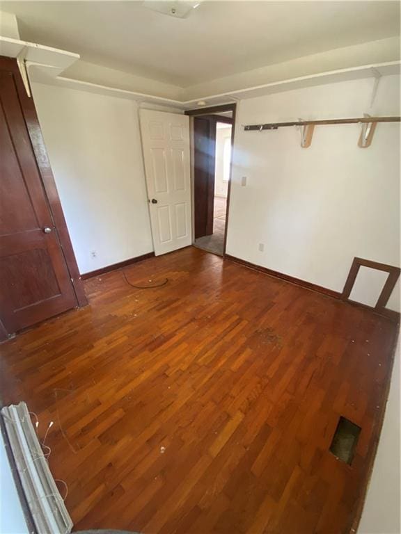 unfurnished bedroom with dark wood-type flooring