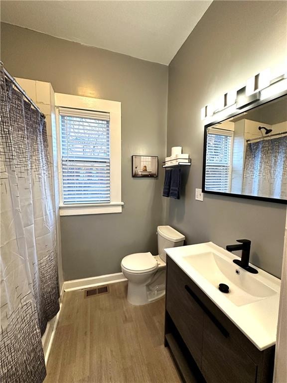 bathroom with curtained shower, vanity, toilet, and hardwood / wood-style flooring