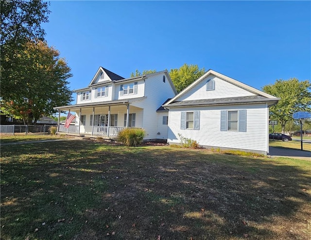 back of house featuring a lawn and covered porch