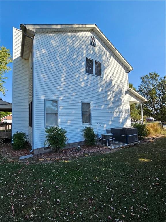 back of property with a lawn, a patio, and central AC unit