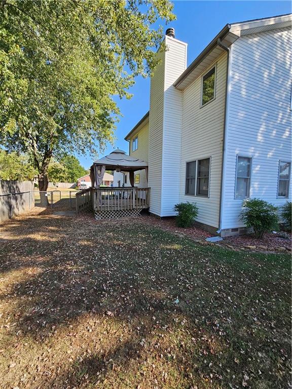 2007 Windsor Dr, Pittsburg, KS 66762 - rear view of house with a deck, fence, a gazebo, and a chimney