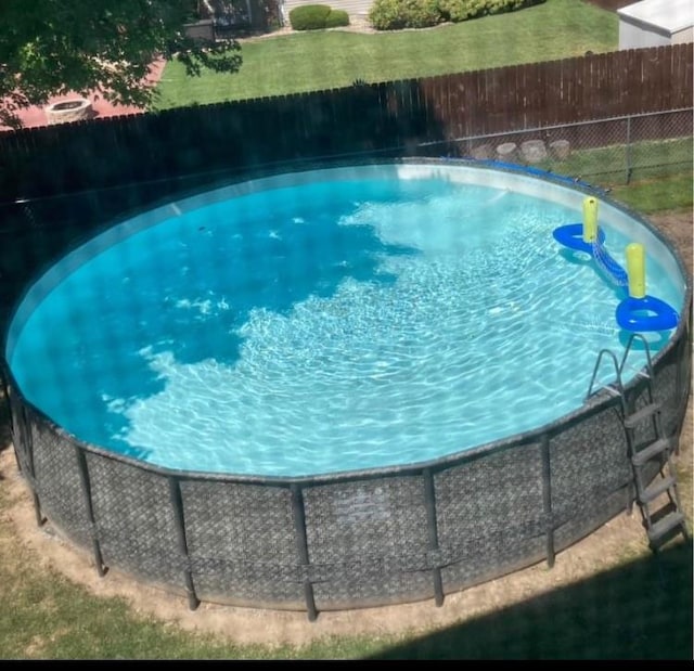 view of swimming pool with a lawn