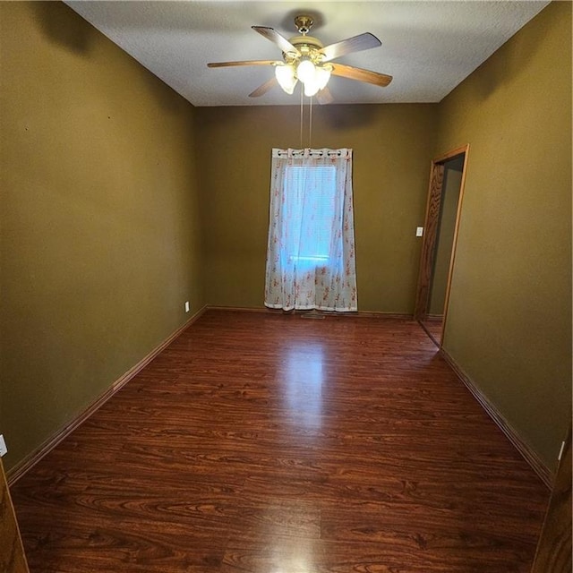 spare room featuring a textured ceiling, dark hardwood / wood-style flooring, and ceiling fan