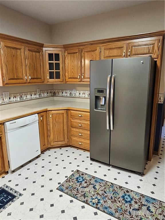 kitchen featuring dishwasher and stainless steel fridge with ice dispenser