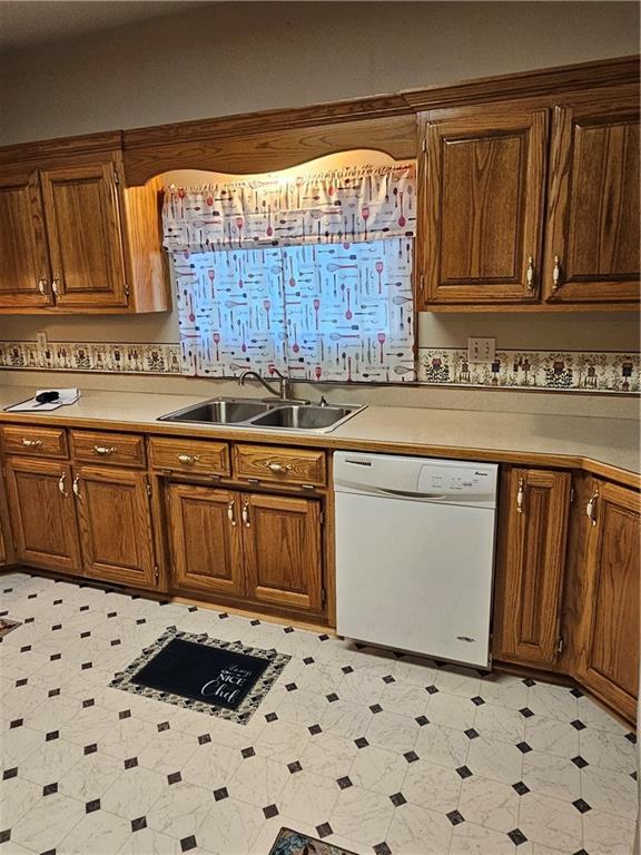 2007 Windsor Dr, Pittsburg, KS 66762 - kitchen featuring a sink, light countertops, white dishwasher, light floors, and brown cabinetry