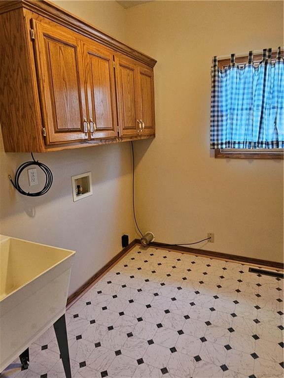 clothes washing area featuring hookup for a washing machine, cabinets, and sink