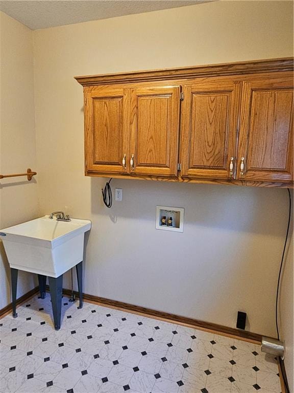 clothes washing area featuring hookup for a washing machine and cabinets