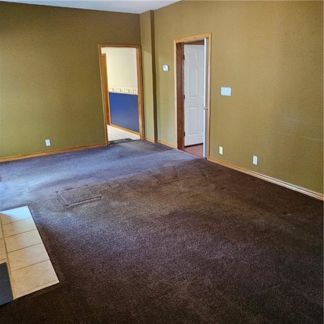 unfurnished room featuring dark carpet